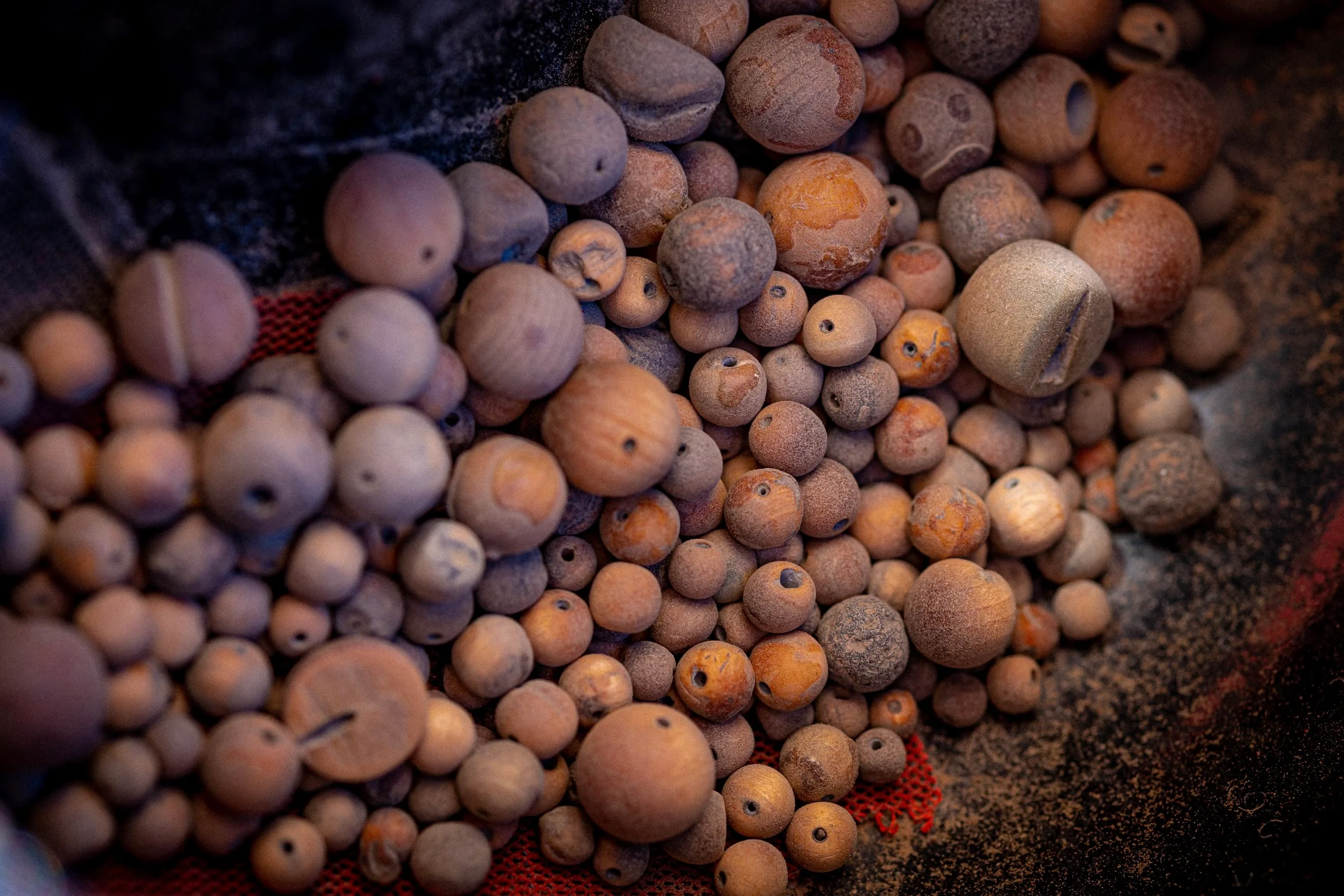 Hundreds of irregular unfinished cypress beads, dusty from sanding